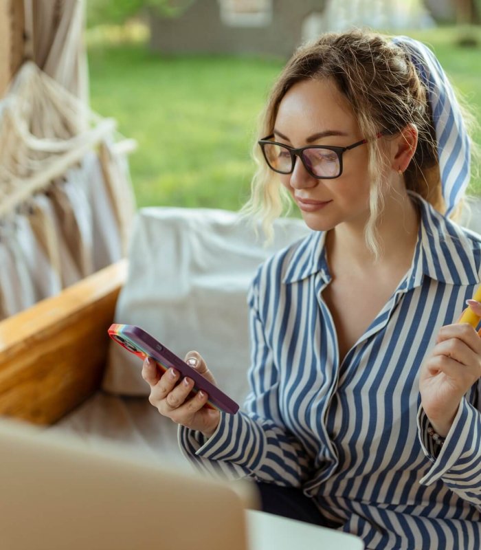 A beautiful girl smokes an electrode cigarette and uses a smartphone. Event Organizer